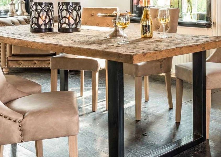 industrial dining table with rustic table top, black metal legs and cream fabric dining chairs