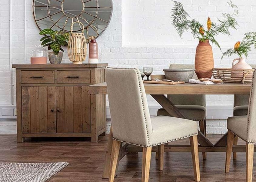 Reclaimed wood sideboard next to wood dining table with cream fabric dining chairs