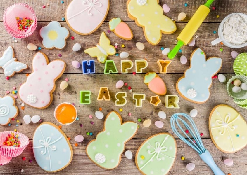 Rustic table with Easter bunny biscuits and baking accessories 