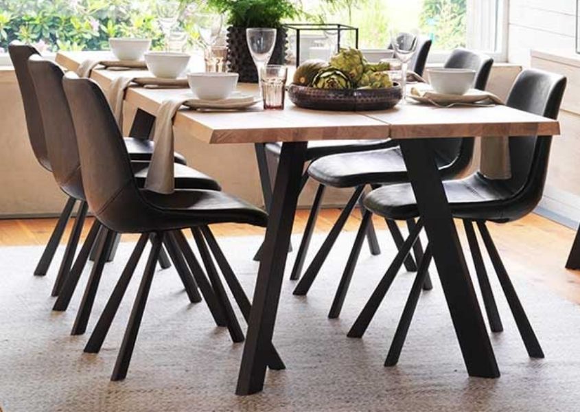 Industrial dining table with black steel legs and dark faux leather dining chairs