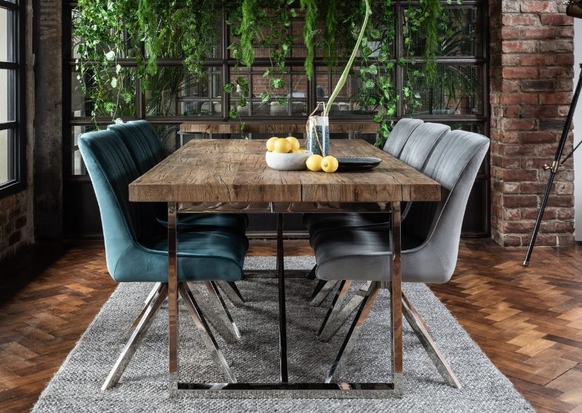 industrial dining table crafted in reclaimed wood with velvet dining chairs