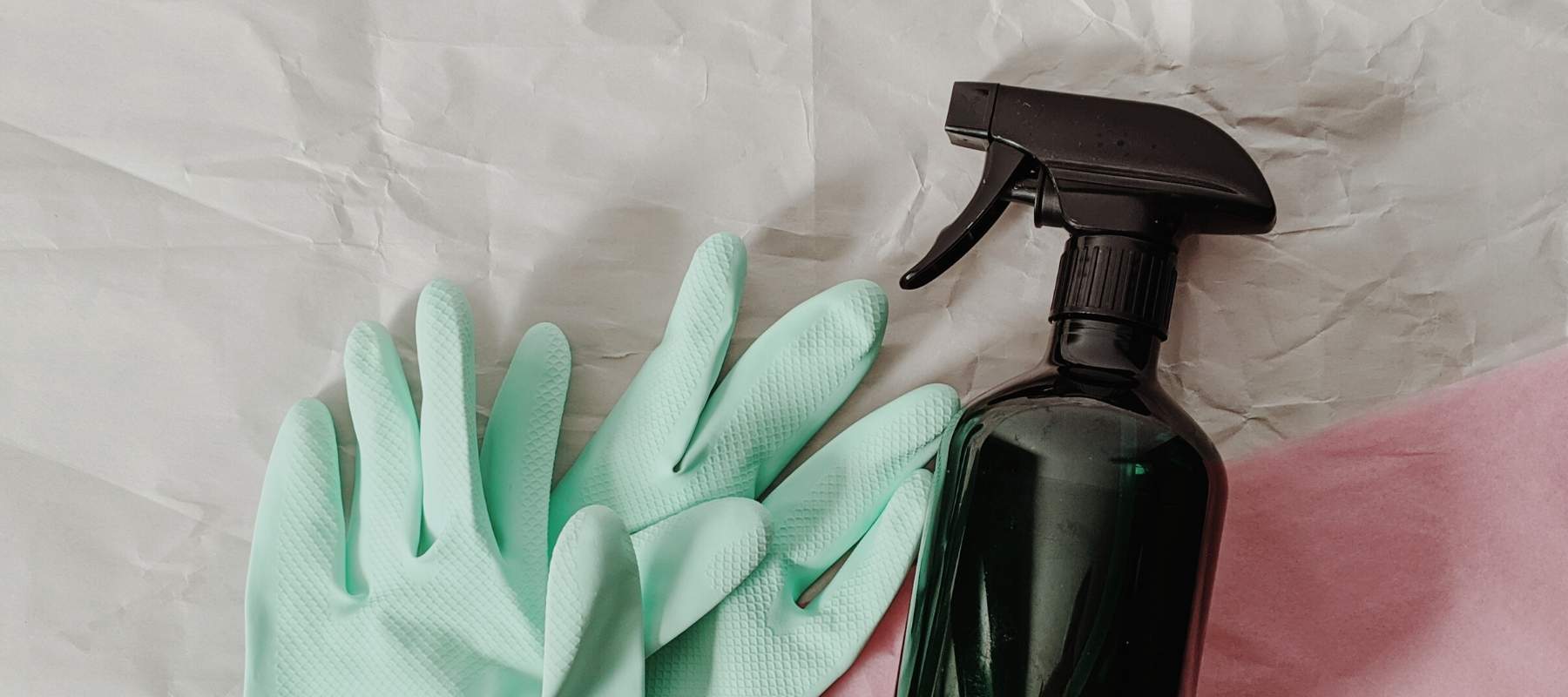 Brown plastic bottle spray and green rubber gloves