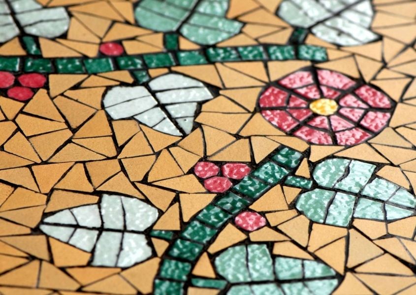 Close up of orange mosaic tiles with a flower design