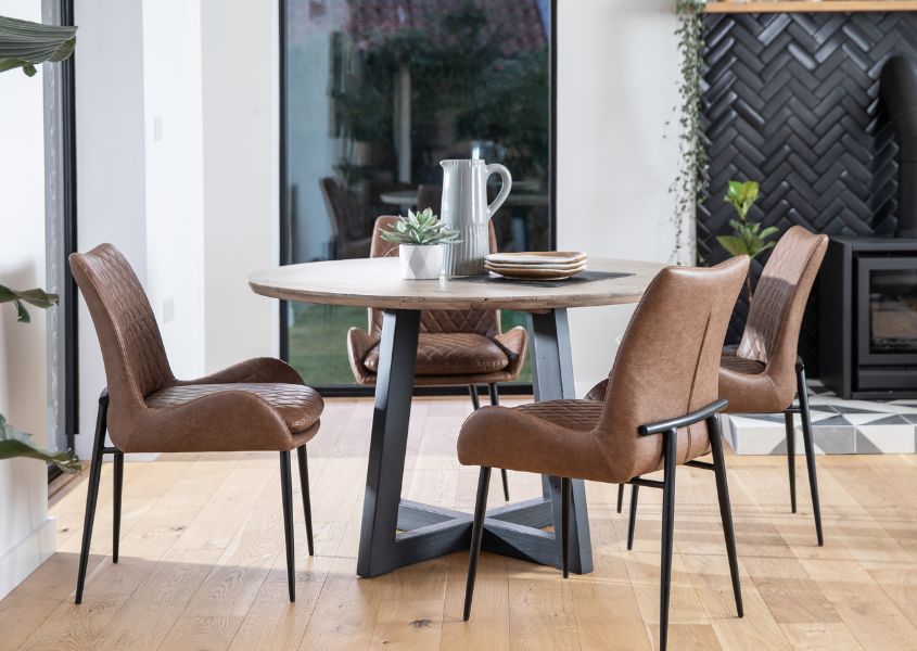 round wood dining table with brown faux leather dining chairs