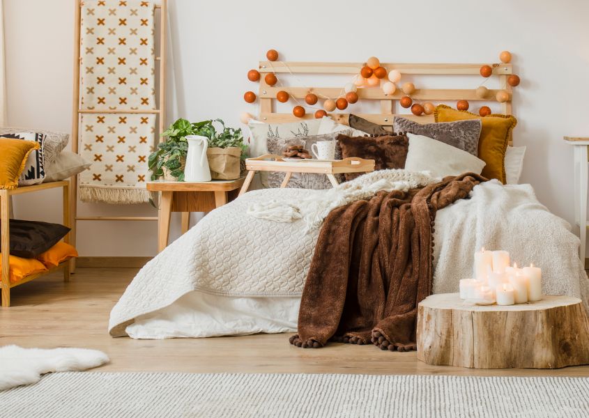 boho style bedroom with wooden bed and layers of covers and blankets