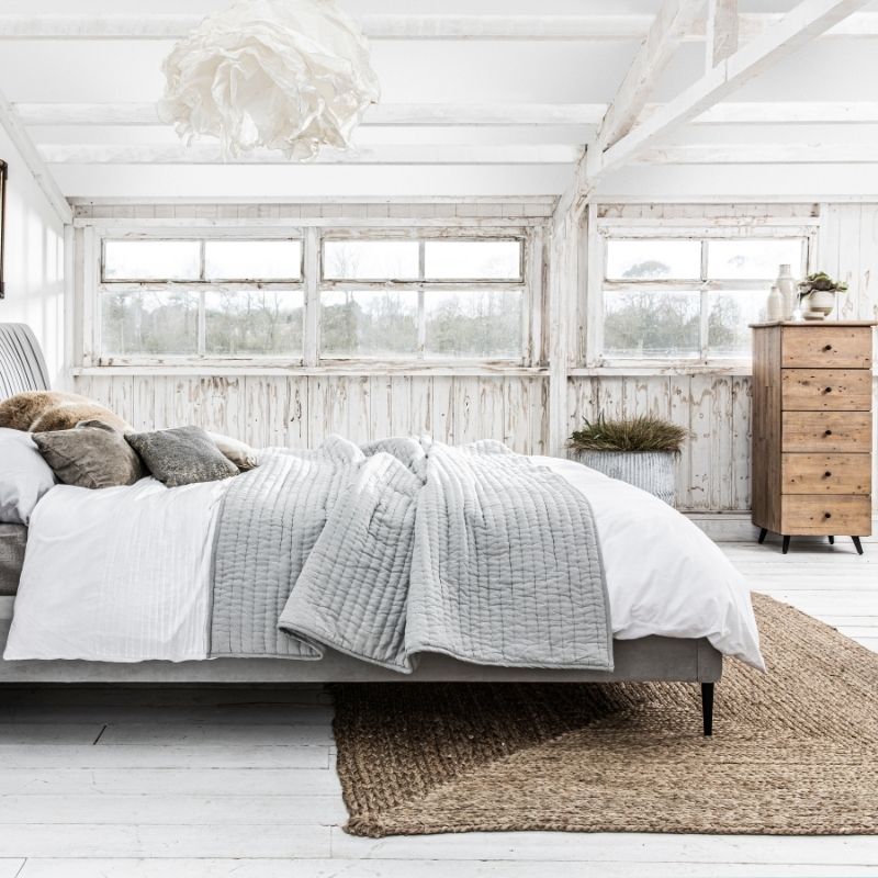 white bedroom with tall rustic sideboard