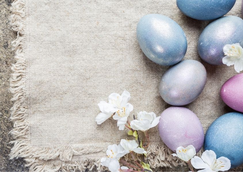 pastel painted eggs and natural linen cloth on rustic dining table