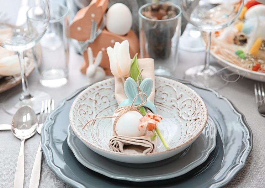 blue dinner plates and Easter decorations on wooden dining table