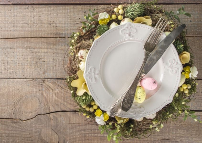 rustic dining table with white plate and Easter decorated tablemat