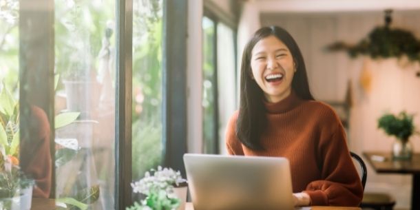 smiling woman at work for how to be happy at work blog
