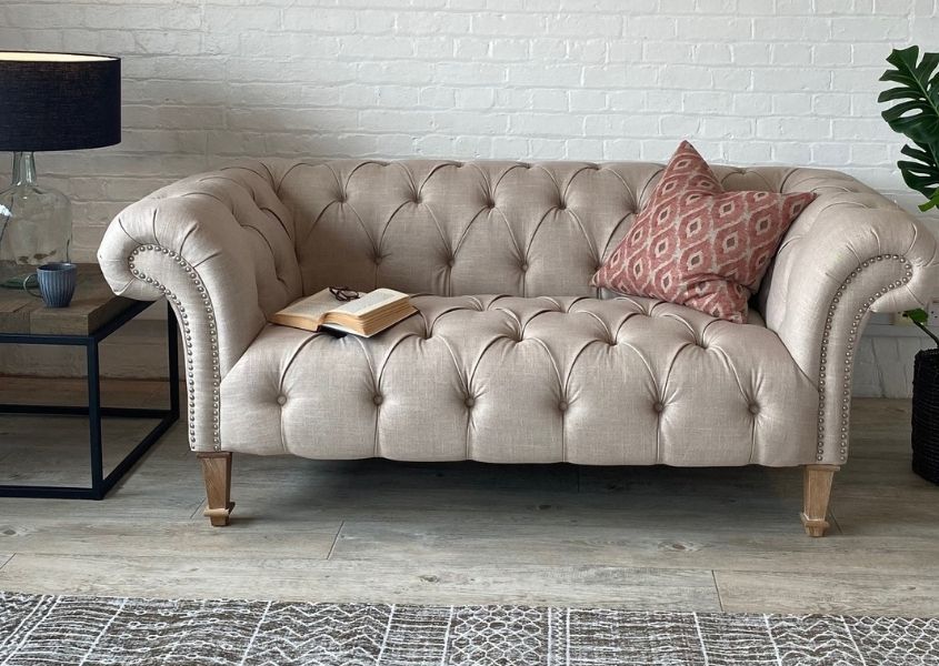 cream chesterfield sofa with pink cushion