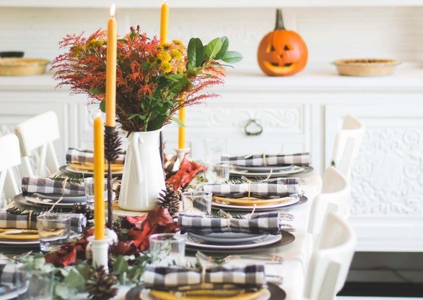 Halloween wooden dining table with black and white gingham napkins and orange pumpkins