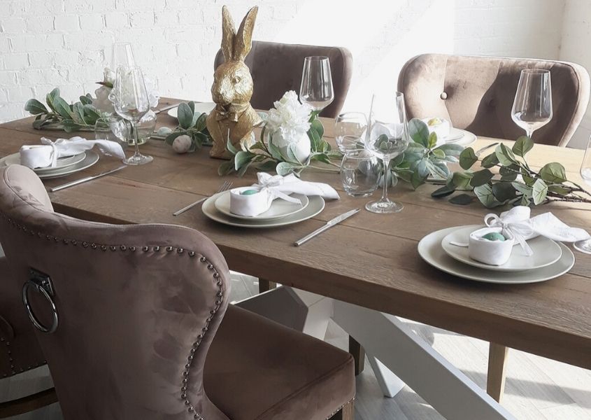 Wooden trestle dining table with golden rabbit statue, green eucalyptus display and and Easter decorations on table