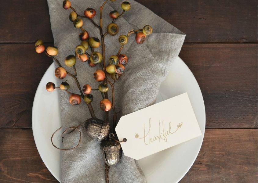 Napkin with bunch of dried berries tied with string and tag saying Thankful