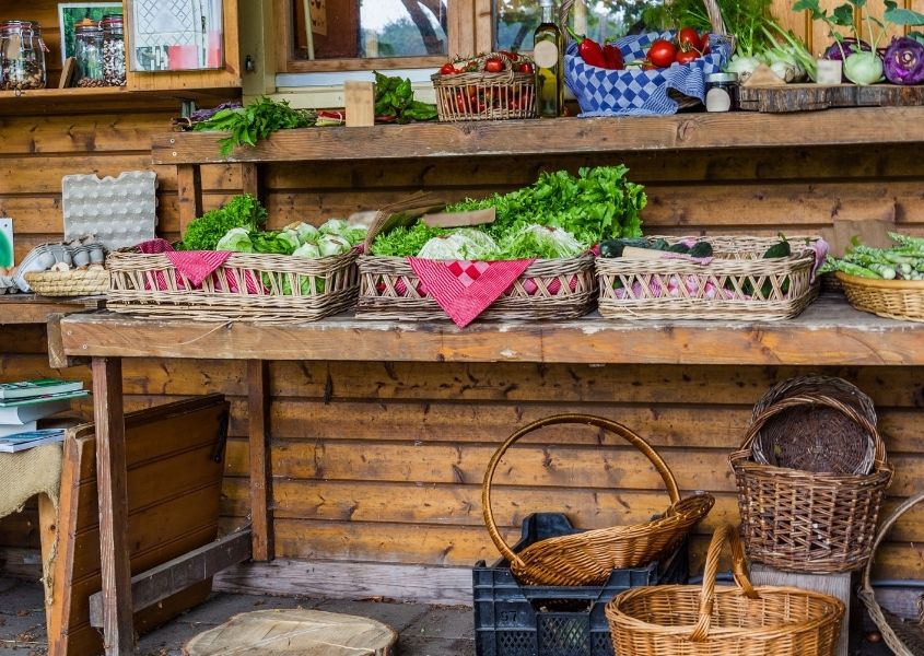 Fruit and vegetables displayed on rustic table and baskets in a farm shop