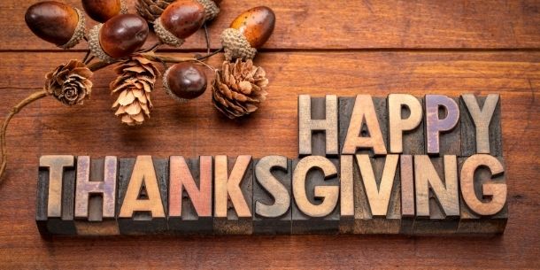 Happy thanksgiving in wooden blogs on rustic wood with scattering of acorns