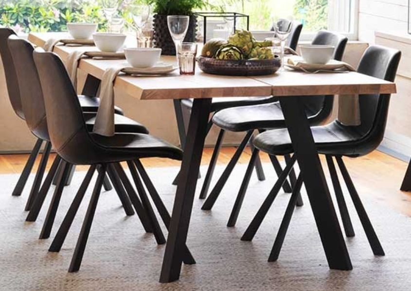 Industrial dining table with black metal legs and brown faux leather dining chairs