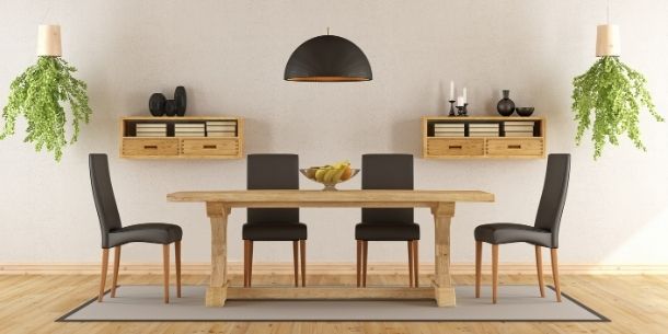 Minimalist dining room with wooden refectory dining table and black dining chairs with two hanging green plants and black ceiling pendant light