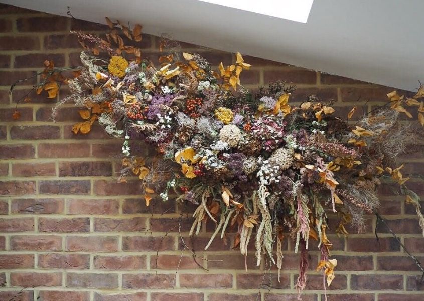 Dried flower display on exposed brick wall