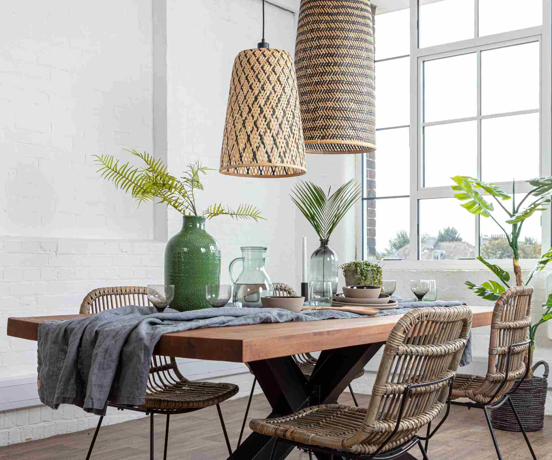 Two bamboo hanging pendant lights above an industrial dining table