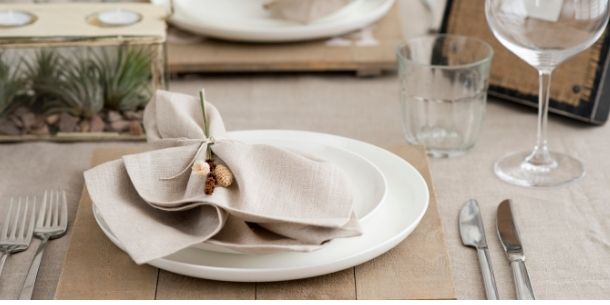 White plate with beige napkin tied with natural straw