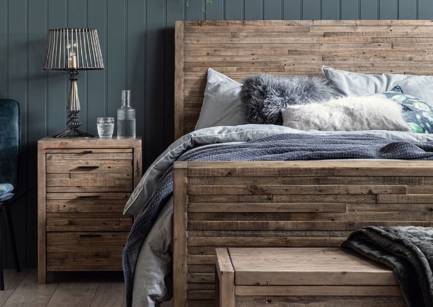reclaimed wood bedside table and rustic bed with grey painted wood panelled wall