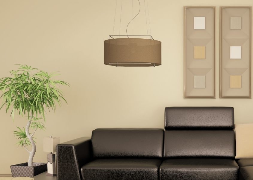 Stone painted living room wall with brown pendant light and dark grey leather sofa
