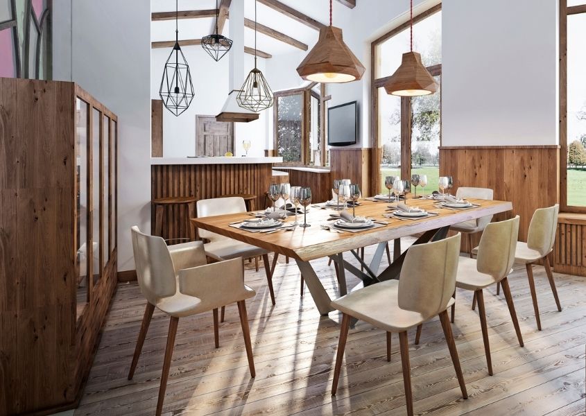 Large wood dining table with wooden chairs in bright dining room with wooden hanging pendant lights