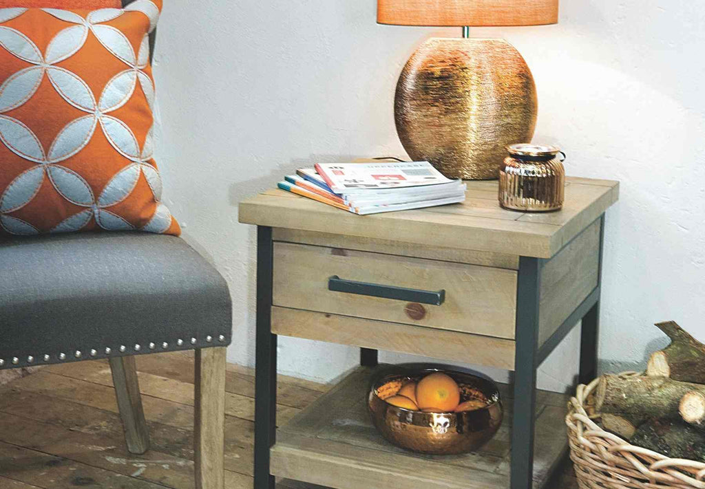 Industrial side table with black steel frame, fabric chair and bronze table lamp