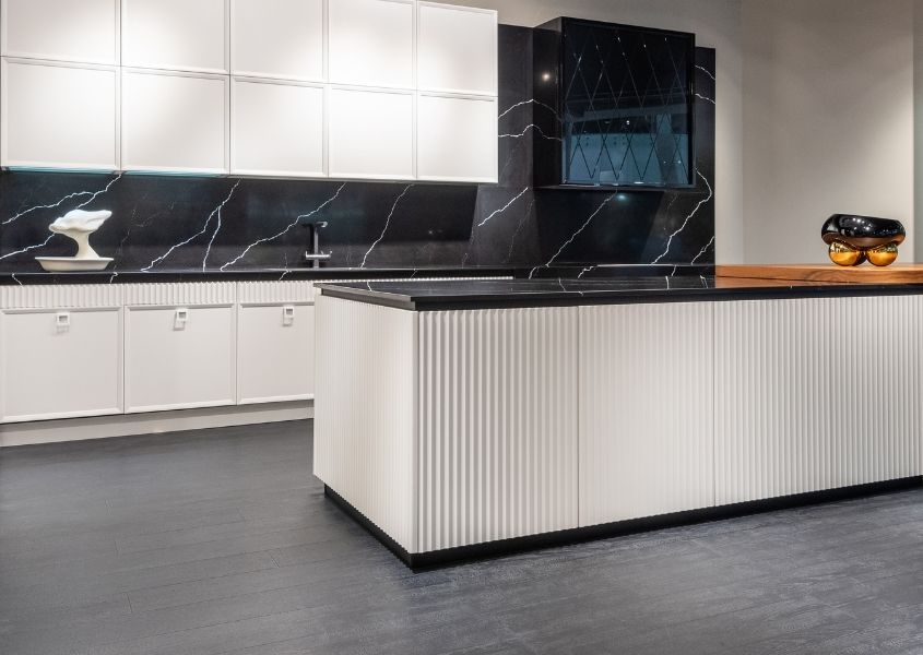 white kitchen units with black worktop and splash back