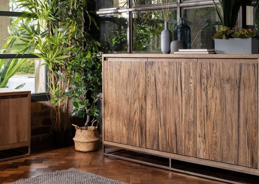 Rustic sideboard with tall green house plants