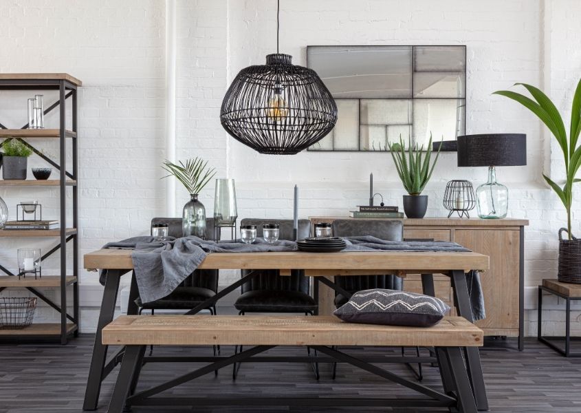 Industrial dining table with dark grey steel frame, matching wooden bench and black bamboo hanging ceiling light