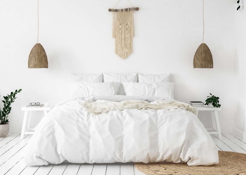 White scheme bedroom with two rustic hanging pendant lights and wall art