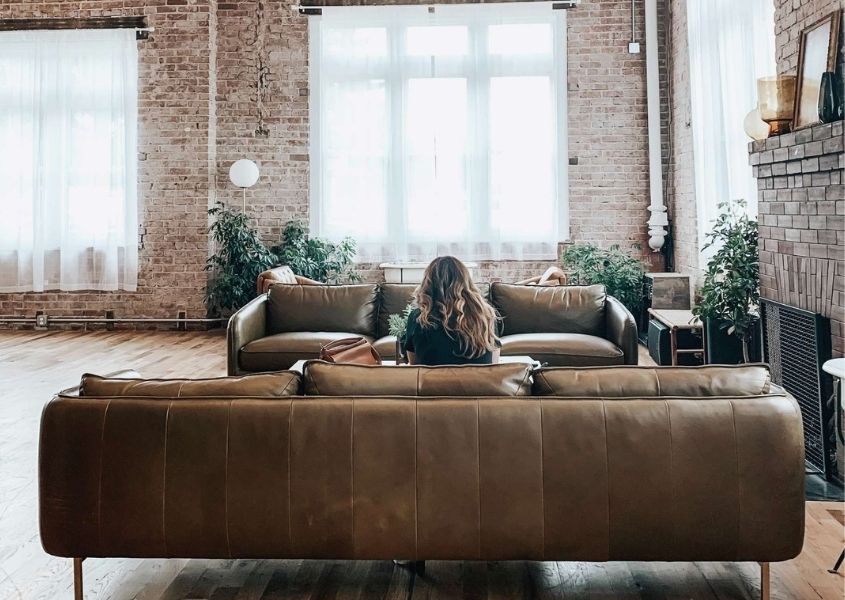 Industrial living room with exposed brick walls, warehouse windows and brown leather sofa