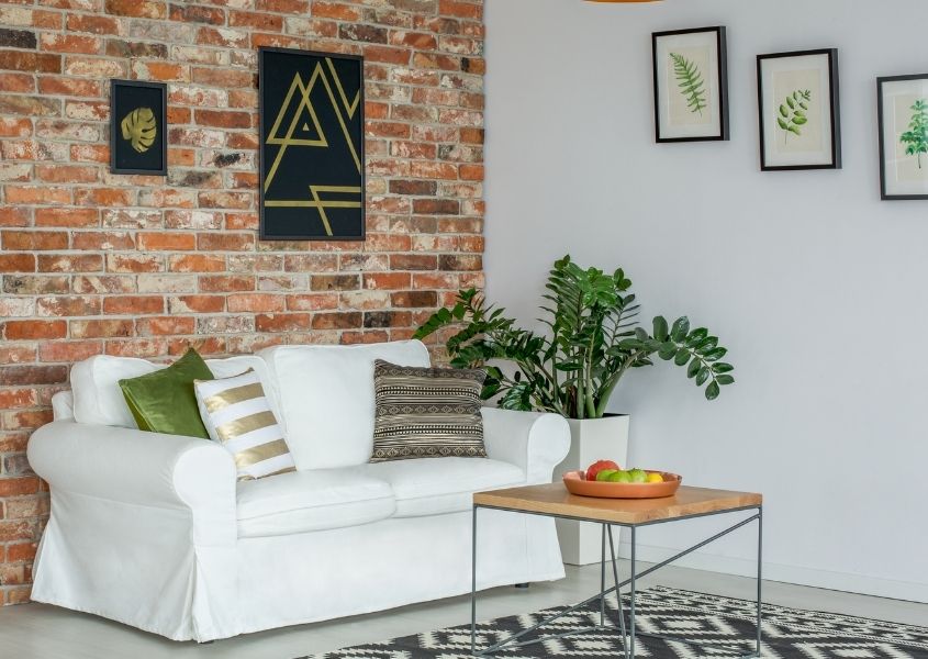 industrial style living room with white fabric sofa and exposed brick wall