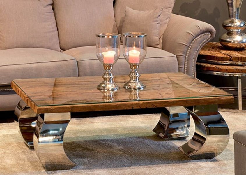 Wooden coffee table with thick shiny metal curved legs with candles on top