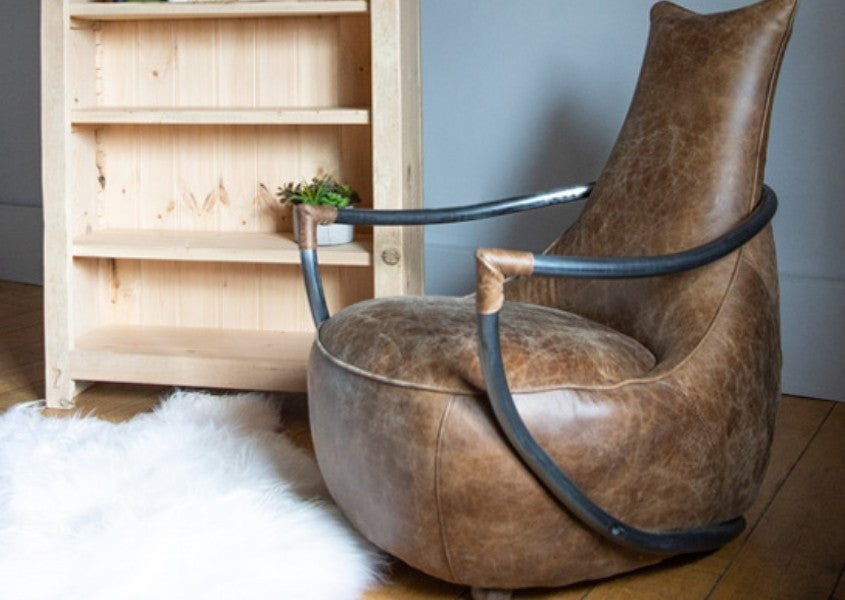Brown leather armchair with metal arms with white sheepskin rug