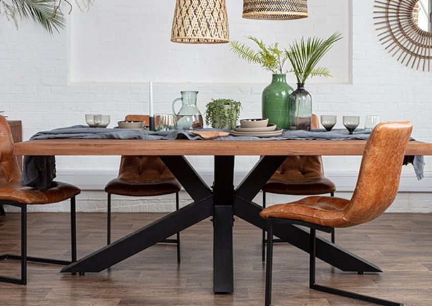 Wooden dining table with black steel spider leg and tan leather industrial dining chairs