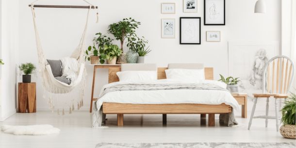 wooden bed in white bedroom with hanging chair