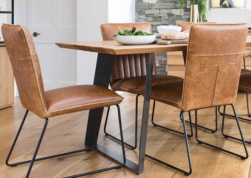 Brown faux leather dining chairs with black steel legs and industrial dining table