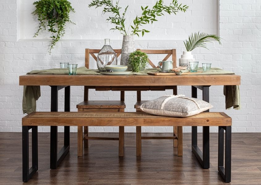 industrial dining table with wooden dining bench and green plants