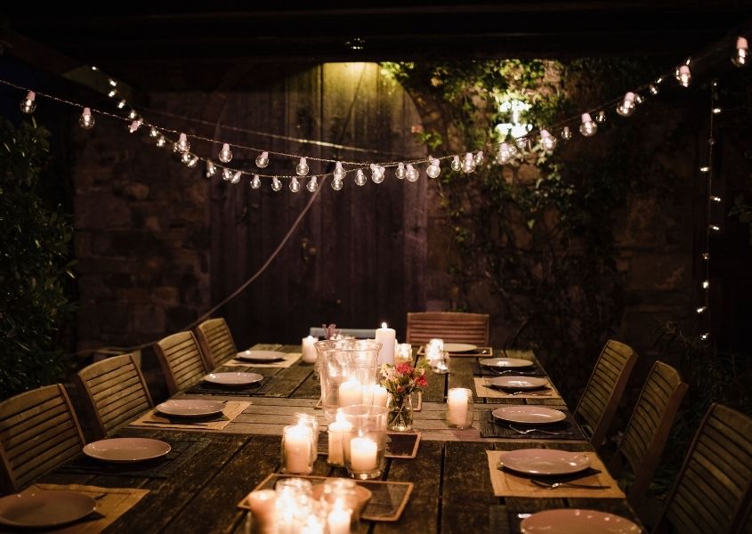 string of fairy lights above rustic dining table for platinum jubilee garden party ideas blog