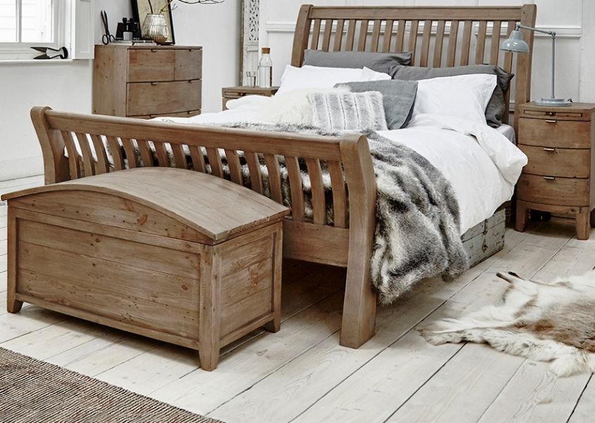 Reclaimed wood bed with matching blanket box and bedside tables with brown faux fur throw on bed