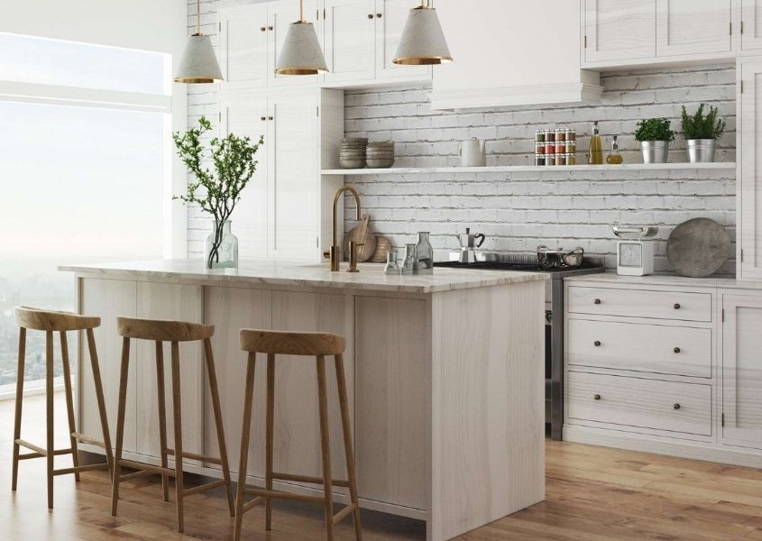 White kitchen with kitchen breakfast bar and three wooden bar stools and hanging pendant lights