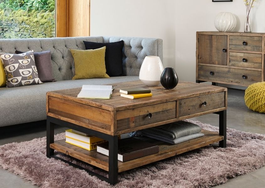 industrial coffee table with two drawers next to grey fabric sofa