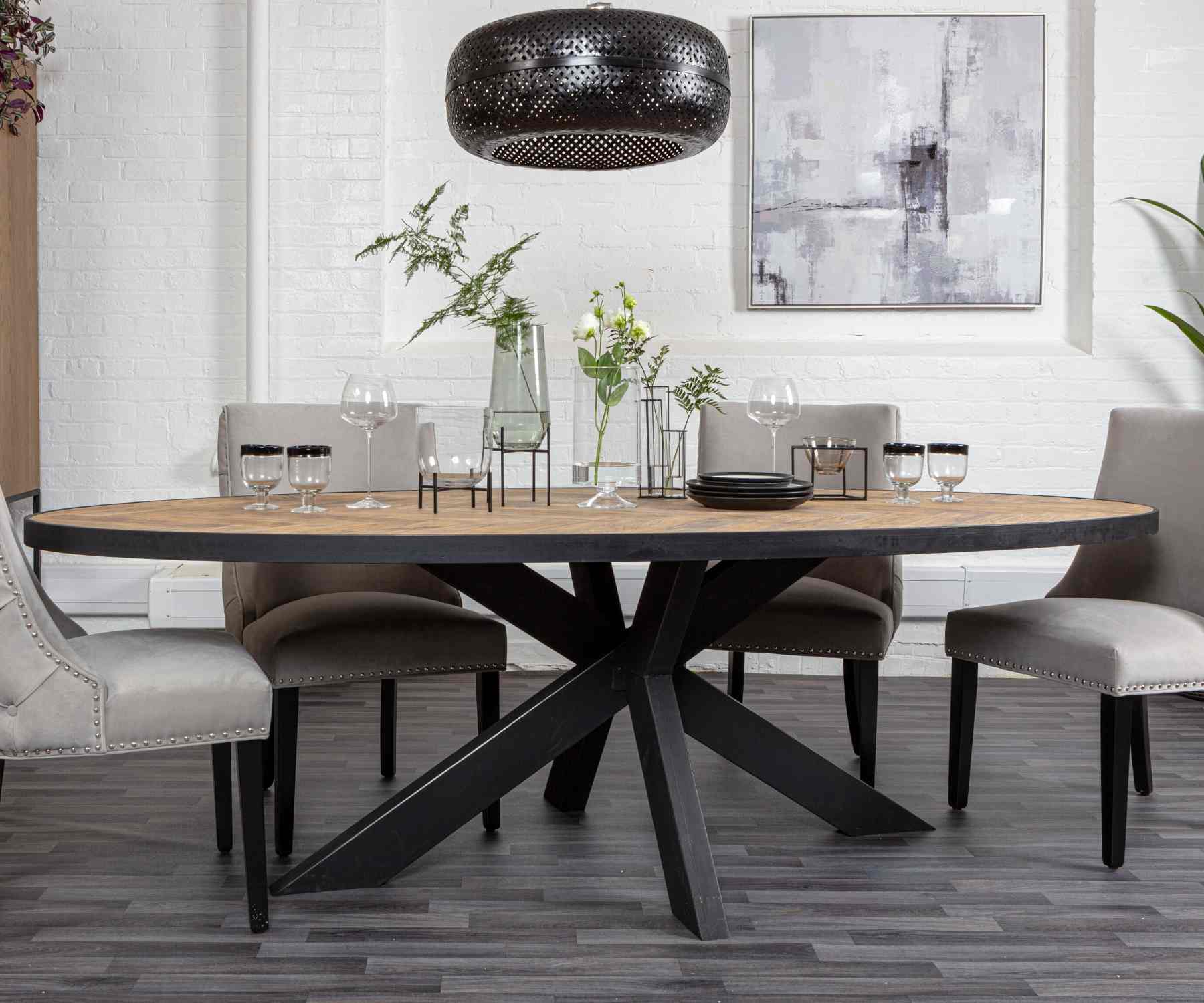 Large oval dining table with reclaimed wood top and black spider legs