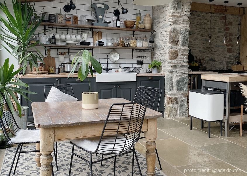 farmhouse kitchen with wooden dining table and exposed brick wall