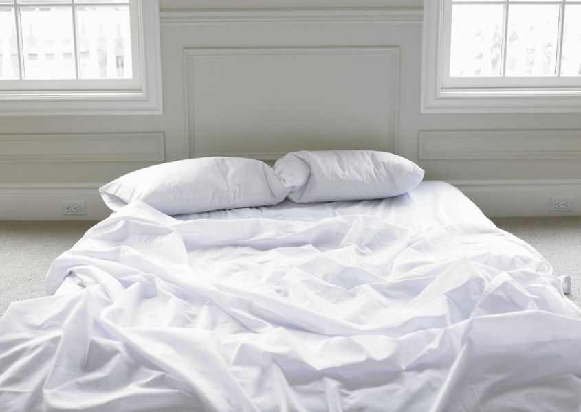 mattress on the floor with white covers