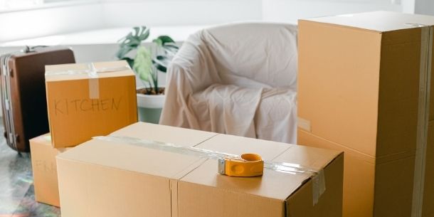 brown removal boxes and armchair with dust sheet