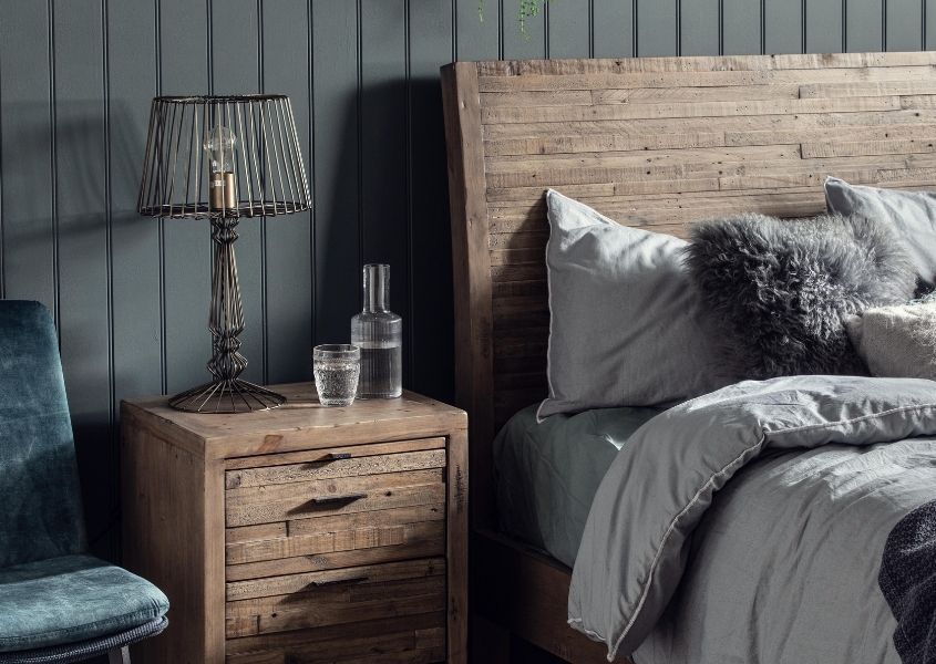 reclaimed wood bedside table against dark grey wood panelled wall